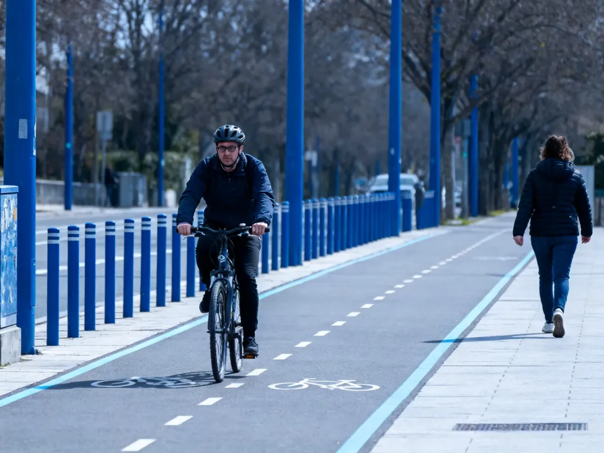 Rowerzysta ustępujący pieszemu na wspólnej drodze dla pieszych i rowerów